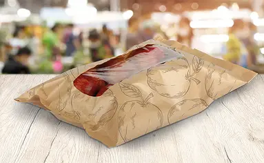 Auf einem Tisch liegen Äpfel in einer recyclingfähigen Kunststoffverpackung