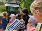 Während einer Ferienbetreuung machen kleine Kinder eine Ausfahrt auf dem Anhänger eines Traktors.