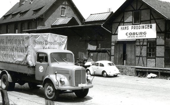 Das historische Bild von 1932 zeigt einen LKW der Firma PRODINGER vor dem Auslieferungslager in Coburg