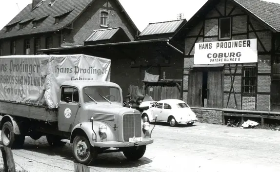 Das historische Bild von 1932 zeigt einen LKW der Firma PRODINGER vor dem Auslieferungslager in Coburg