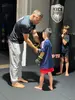 Kindern wird Schutzausrüstung fürs Kickboxen angezogen