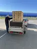 Auf einem Anhänger stapeln Holzpaletten