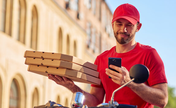 Pizzalieferant hält Snackverpackungen in der Hand