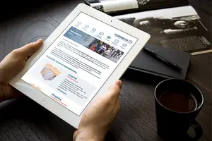 Jemand hält ein Tablet in der Hand und liest den Newsletter von PRODINGER