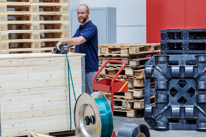 Holzpalette wird mit hilfe des BXT-Handumreifungsgerät mit nachhaltigem PP-Umreifungsband umreift und so geschützt.