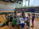 Kindern werden die Grundlagen von Tischtennis erklärt