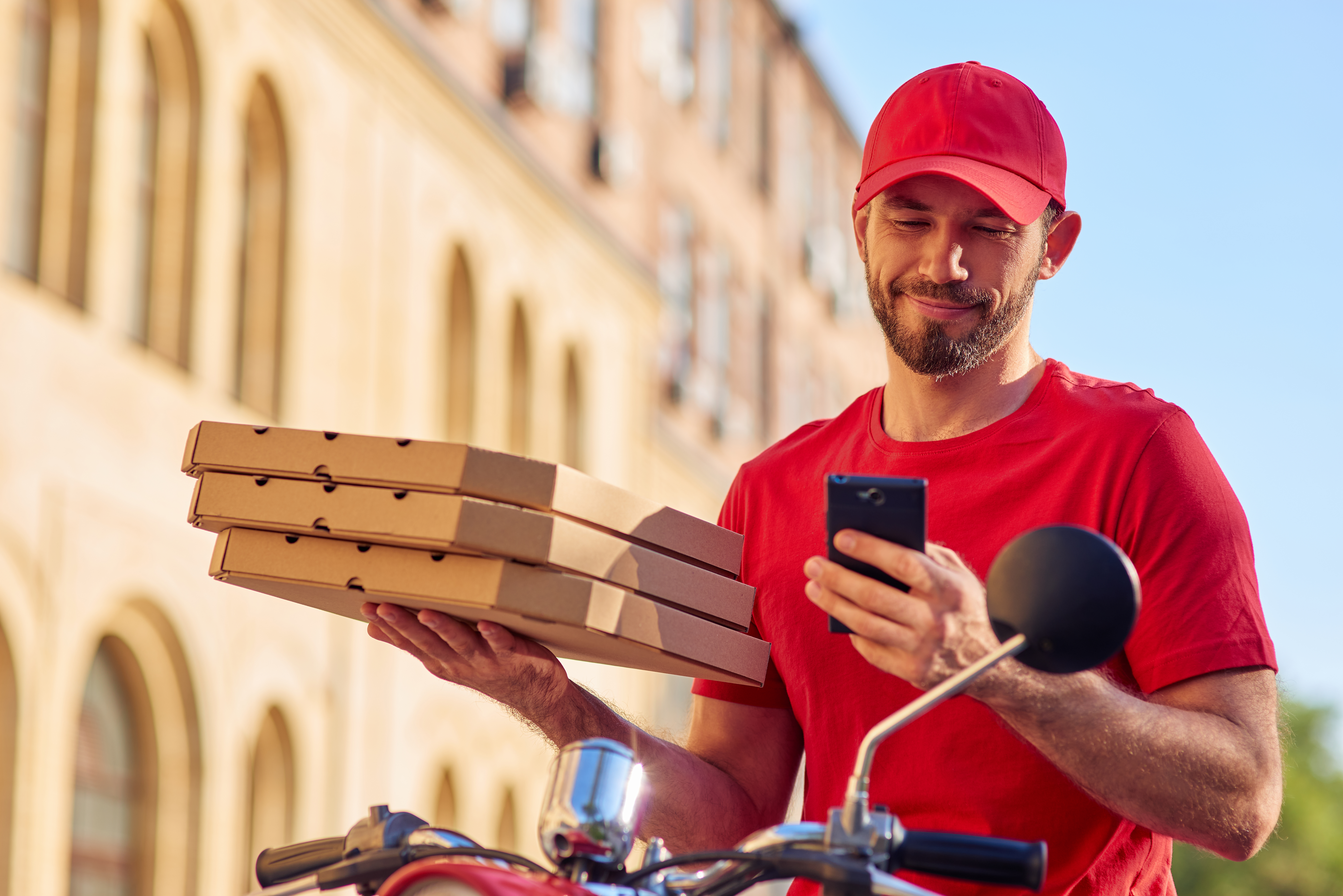 Pizzalieferant hält Snackverpackungen in der Hand